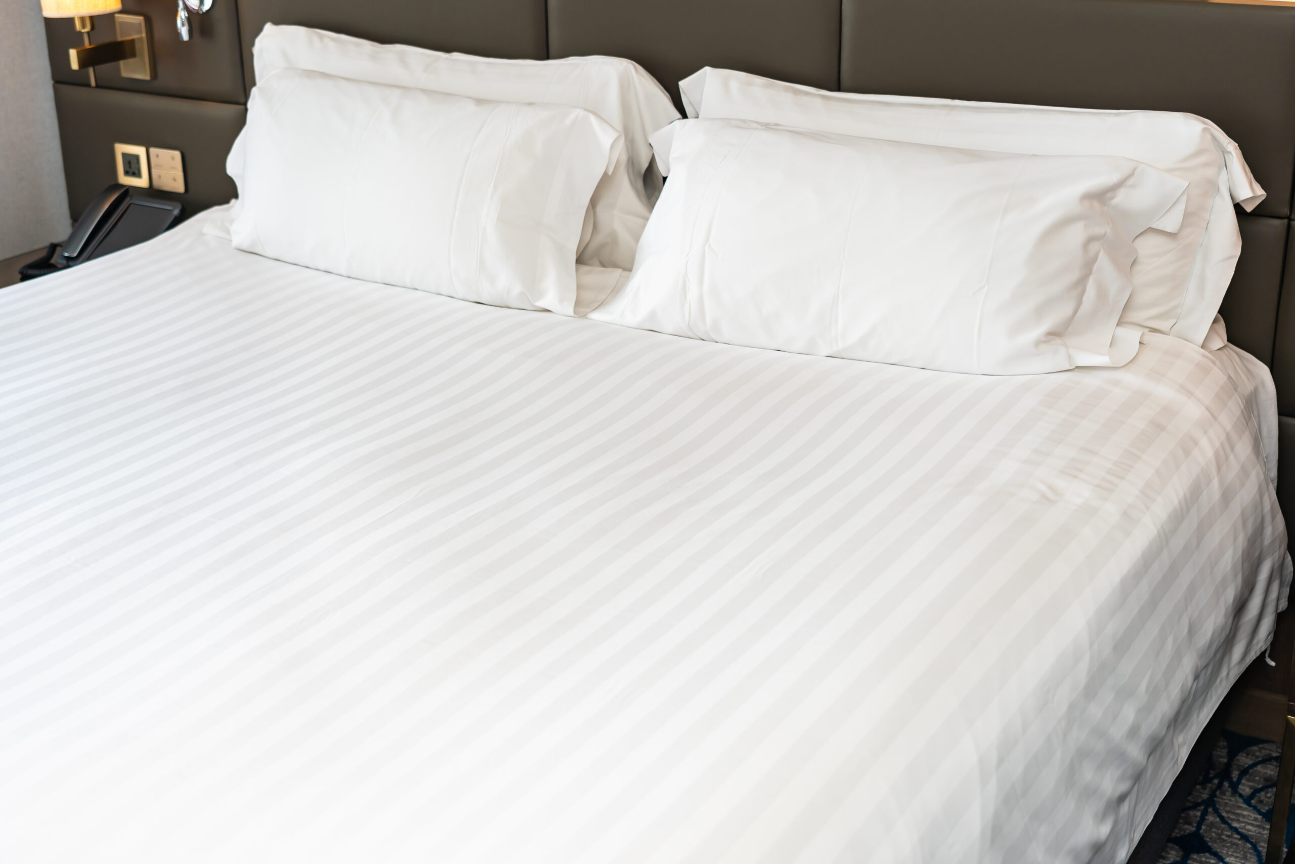 White bedsheet with subtle stripe pattern, neatly arranged to showcase texture and premium quality by Elysian Thread